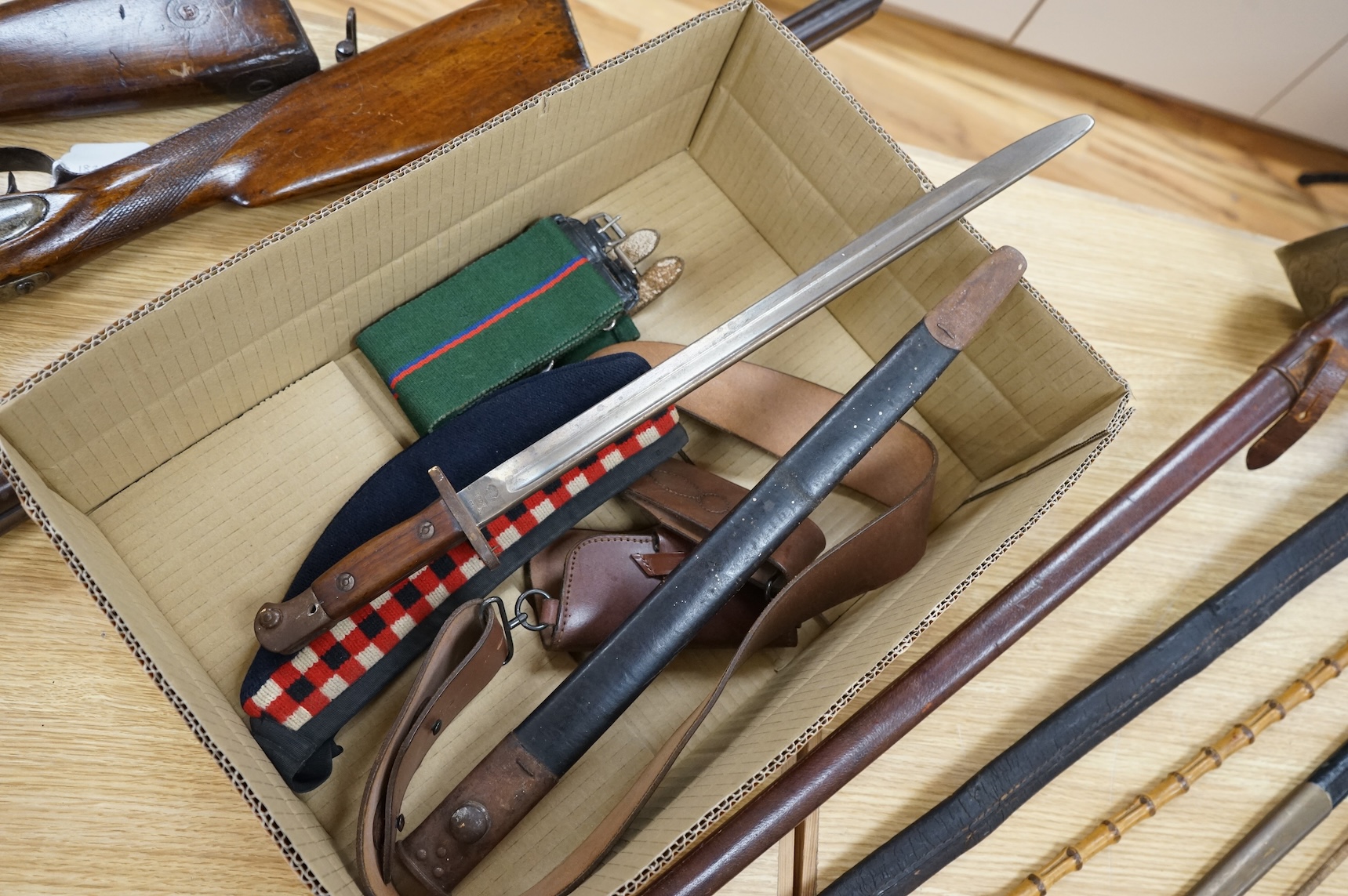 A 1907 bayonet in its scabbard with the tip of the blade shortened, together with a Glengarry cap of the KOSB, post 1902 badge and a brown leather shoulder belt and pouch with QE2 bronze badge of the Royal Artillery